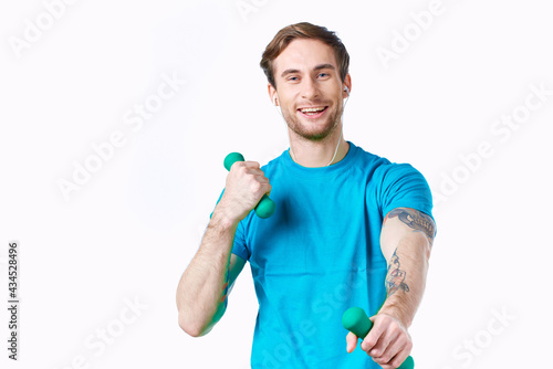 man in blue t-shirt holding dumbbells fitness exercise