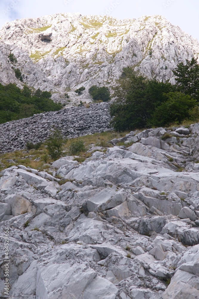 Marble debris on the mountains of the Apuan Alps in Tuscany.The Apuan mountains between the Foce di Giovo and the Passo delle Pecore in Orto di Donna. Apuan Alps, Tuscany, Italy. Marble debris on the mountains of the Apuan Alps in Tuscany.The Apuan mountains between the Foce di Giovo and the Passo delle Pecore in Orto di Donna. Apuan Alps, Tuscany, Italy.