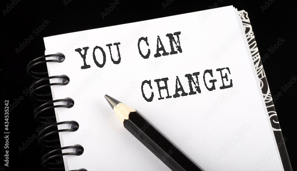 YOU CAN CHANGE written text in small notebook on a black background YOU CAN CHANGE written text in small notebook on a black background
