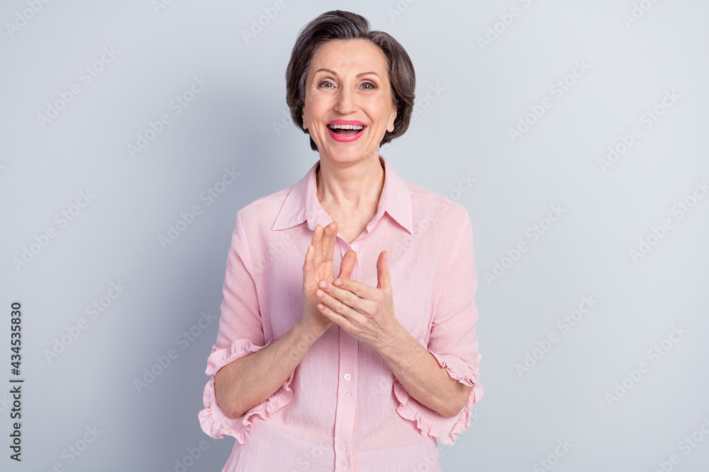 Portrait of attractive cheerful middle-aged woman applauding you success isolated over gray pastel color background