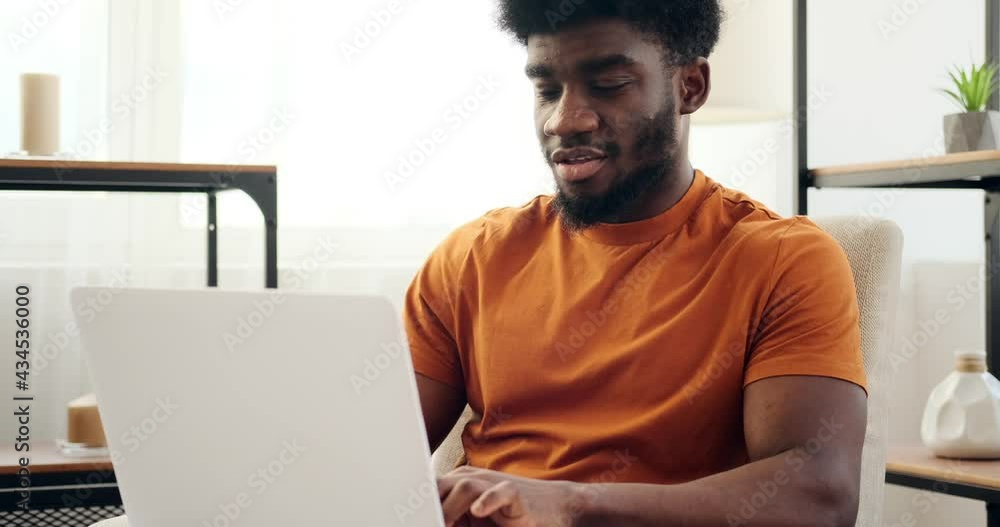 Thoughtful man using laptop sitting on armchair at home Thoughtful man using laptop sitting on armchair at home