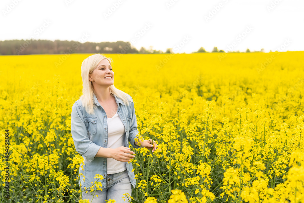 Portrait of young beautiful woman in blooming rapeseed meadow Portrait of young beautiful woman in blooming rapeseed meadow