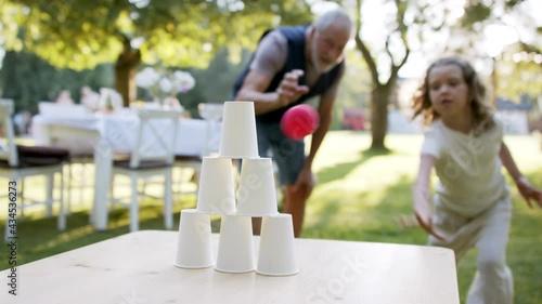 Family having a garden party, grandfather playing games with kids. photo