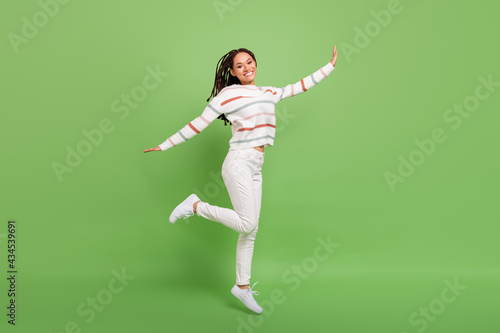 Full size profile side photo of excited young black girl happy positive smile isolated over green color background