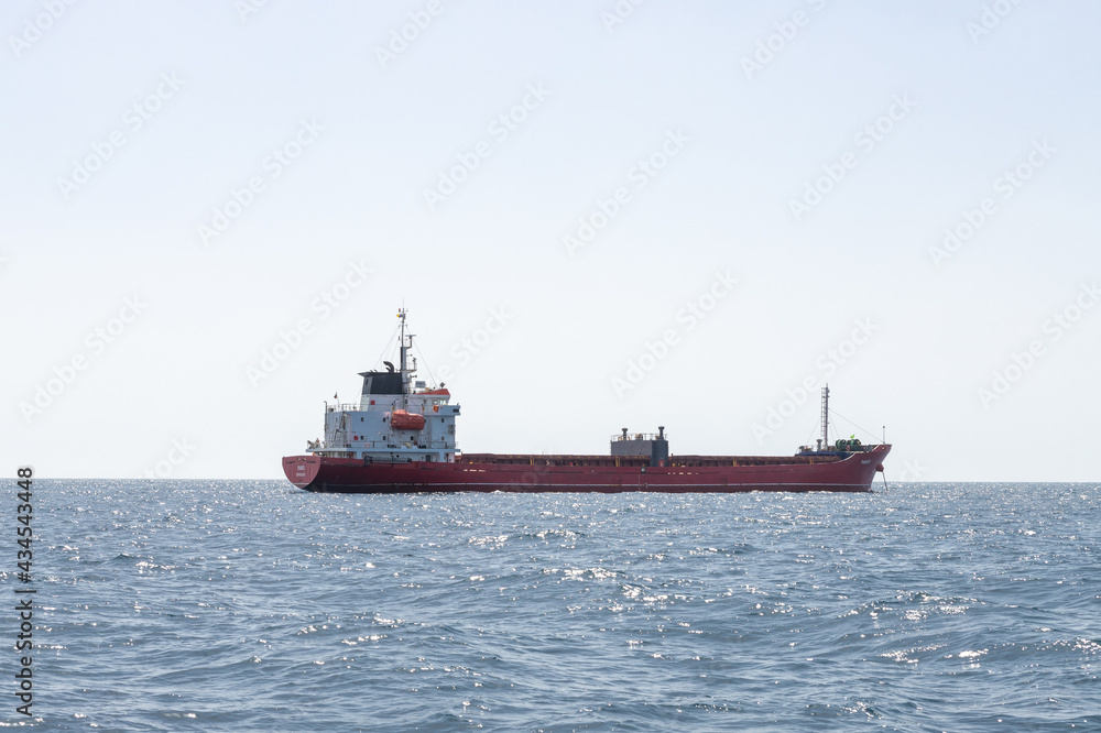 A large cargo ship is in the roadstead in the waters of the Haifa Bay in the Mediterranean Sea, near the port of Haifa in Israel