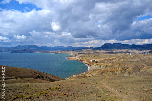 empty rocky sea coast and the mountains under dramatic sky 