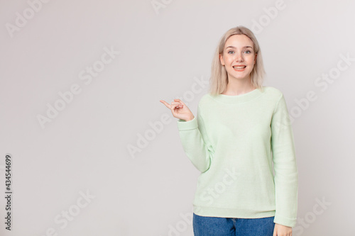 blond pretty woman looking happy and pleasantly surprised