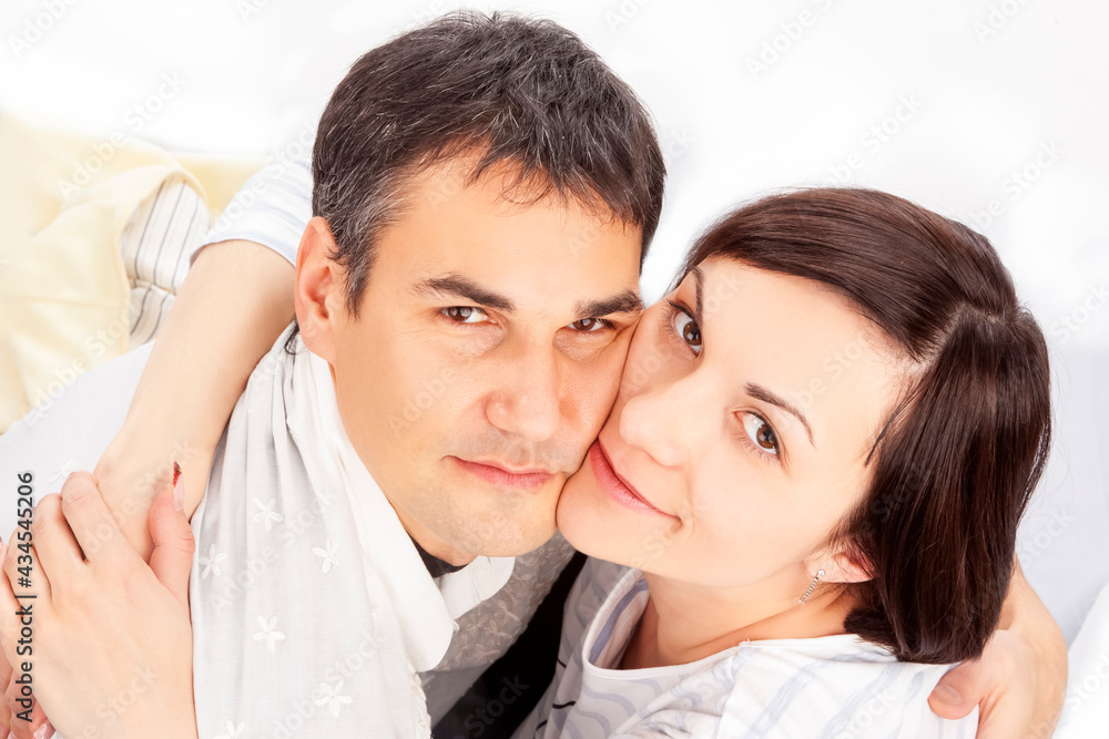 Upper View of Portrait of Caucasian Family Couple Sitting Embraced Against White Upper View of Portrait of Caucasian Family Couple Sitting Embraced Against White