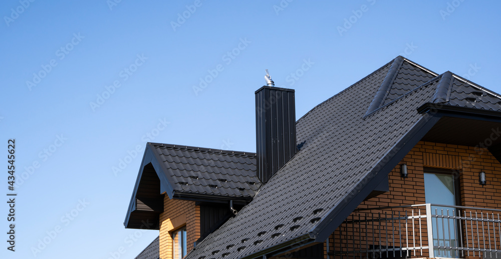Brown corrugated metal profile roof installed on a modern house. The roof of corrugated sheet. Roofing of metal profile wavy shape. Modern roof made of metal. Metal roofing.