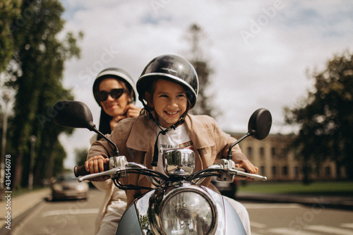 scooter riding mom and daughter in the park