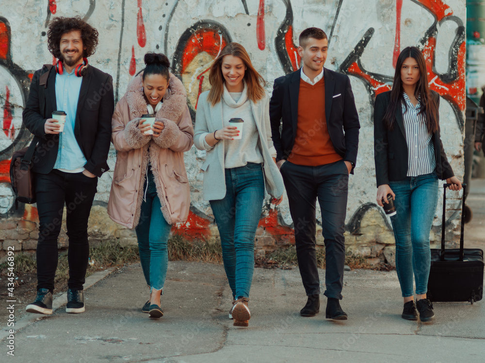 Naklejka premium young people stand in front of a drawn wall in an abandoned street.