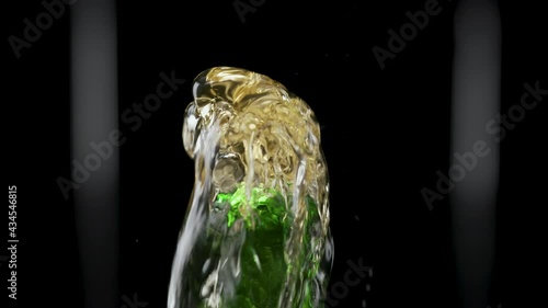 Macro shot of cap popping out of green glass bottle and explosion of splash carbonated beer. Amber liquid under pressure bursts out of bottle and fountains up. Black background. Close up. Slow motion. photo