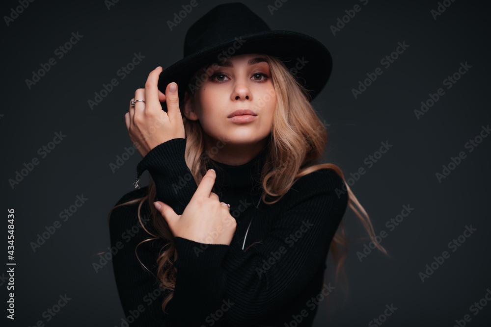 Portrait of a young beautiful woman in black hat on black background Portrait of a young beautiful woman in black hat on black background