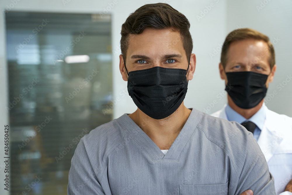 Two doctors in face masks looking at the camera Two doctors in face masks looking at the camera
