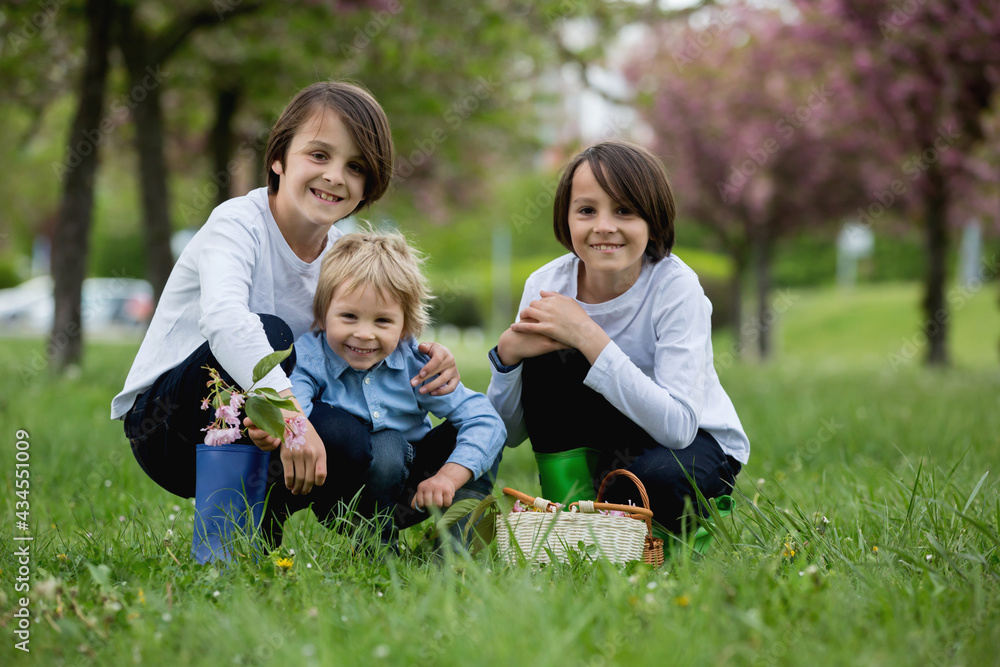 Happy children of different age groups, running together in the park, springtime, having fun