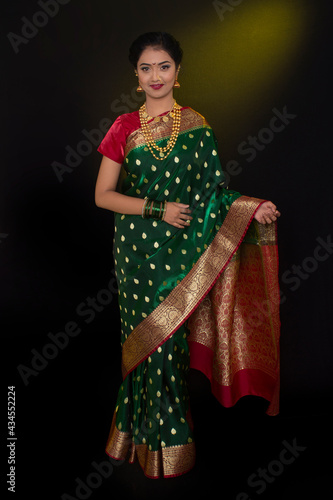 Indian model wearing traditional Maharashtrian bridal green sari and jewelry. Looking at Camera. Full length shot