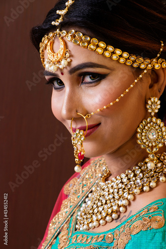 Indian model wearing traditional Maharashtrian bridal green sari and jewelry. Looking at Camera. Face close-up