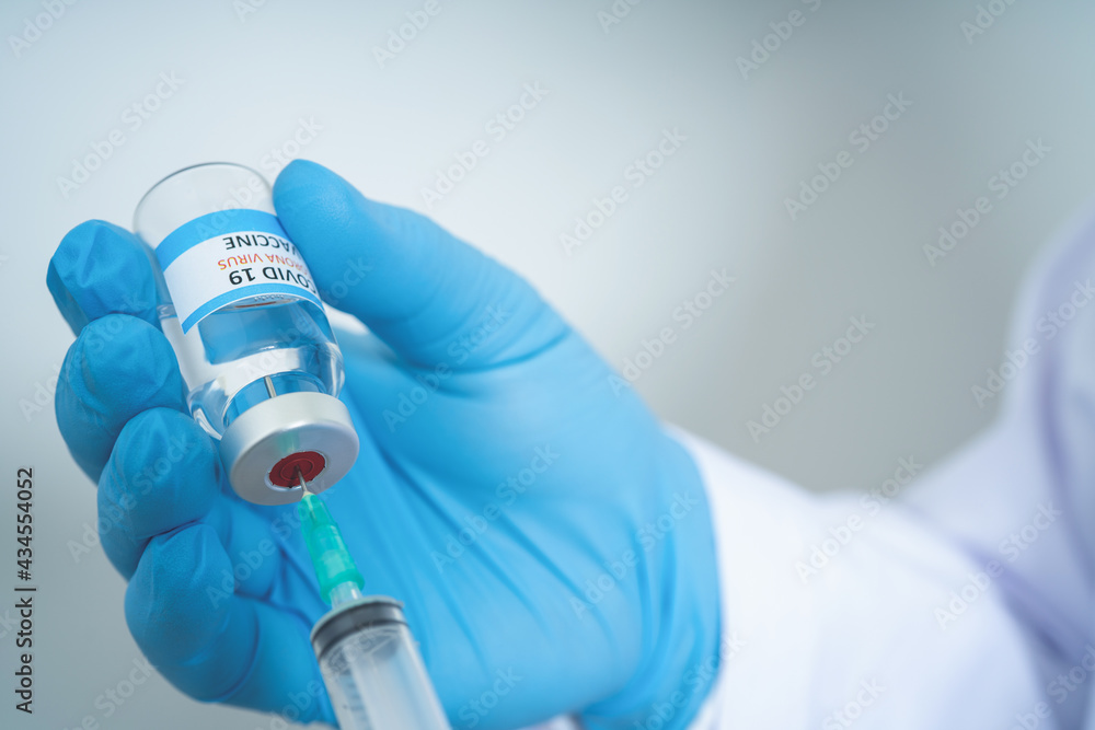 Male Doctor wearing PPE with a stethoscope on shoulder and holding syringe COVID-19 vaccine CORONA vaccine concept Healthcare and Medical Male Doctor wearing PPE with a stethoscope on shoulder and holding syringe COVID-19 vaccine CORONA vaccine concept Healthcare and Medical