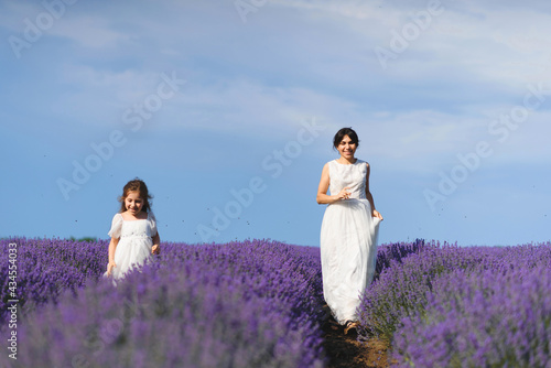 running mother and daughter in white dresses in lavender