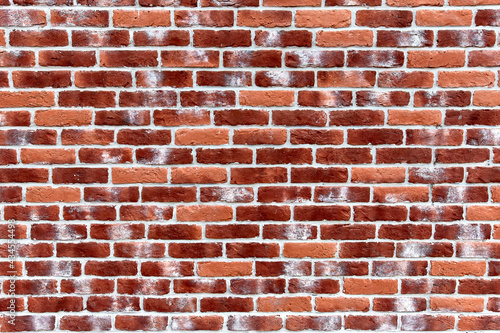 Wall texture of bright red brick with decorative white spots  straight view