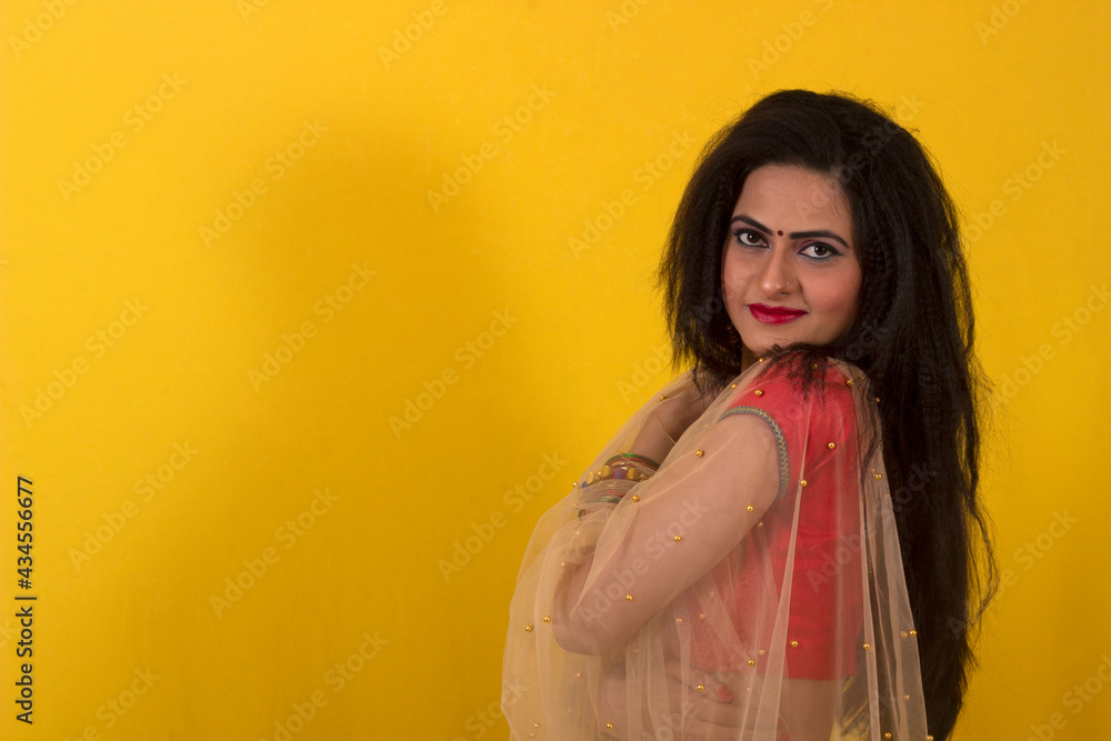 Fototapeta premium Young Indian female model in Ghagra Choli and long hair looking at camera