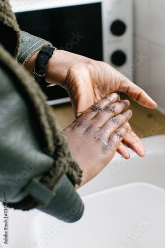 Close up of person washing hands in kitchen 