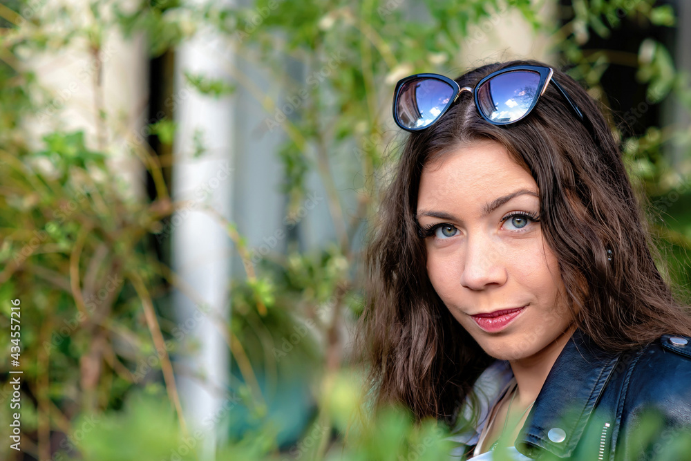 portrait of an slim emotional dark-haired teenager woman in a city park on a sunny day portrait of an slim emotional dark-haired teenager woman in a city park on a sunny day