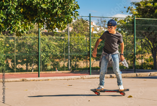 Caucasian boy with cap skating with his skateboard in a skate park