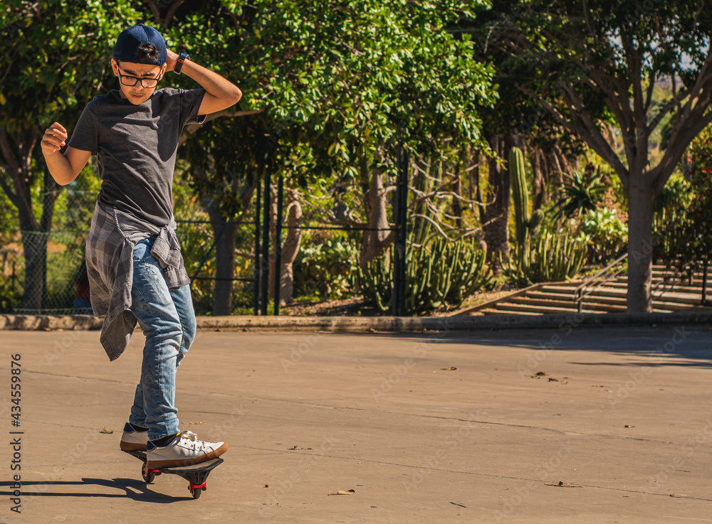 Fototapeta premium Caucasian boy with cap skating with his skateboard in a skate park