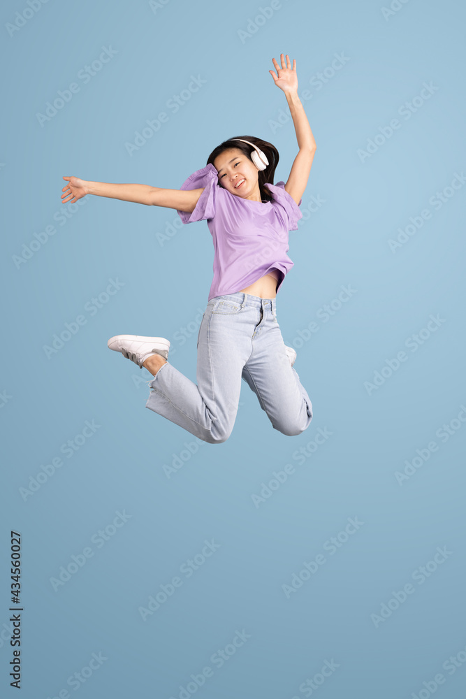 Asian young woman's portrait on blue studio background. Concept of human emotions, facial expression, youth, sales, ad.