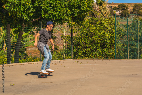Caucasian boy with cap skating with his skateboard in a skate park