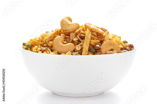 Close up of Rich Spicy Kaju Mixture Indian namkeen (snacks) on a ceramic white bowl.