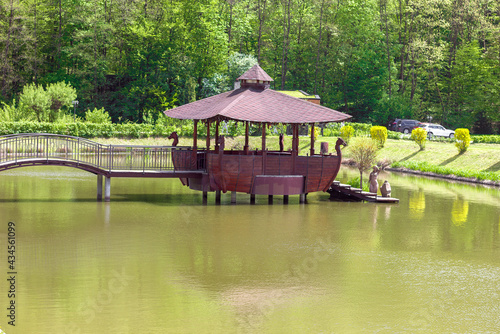 Wooden building gazebo restaurant on the water in the form of an old ship, outdoor recreation in the park