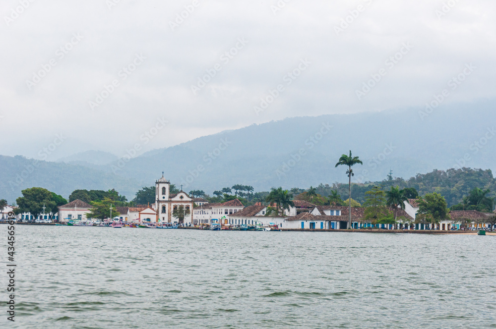 View of Paraty's sea with some clouds in the sky and boats on the water.