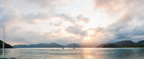 Colorful sunset view in dusk beach tropical summer climate with mountains in the background