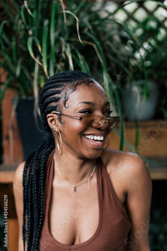 Girl with braids glasses and grills laughing 