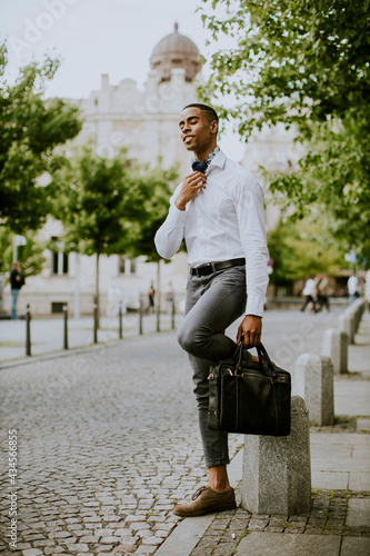 Young African American businessman waitng a taxi on a street photo