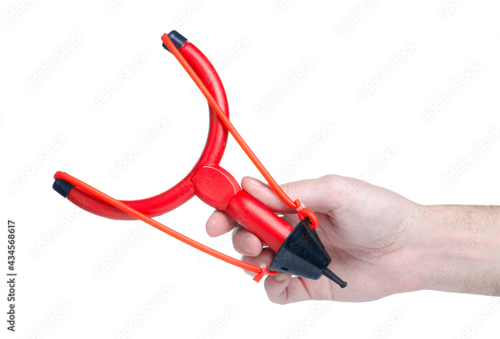 Red plastic slingshot in hand on white background isolationwhite background isolation Red plastic slingshot in hand on white background isolationwhite background isolation