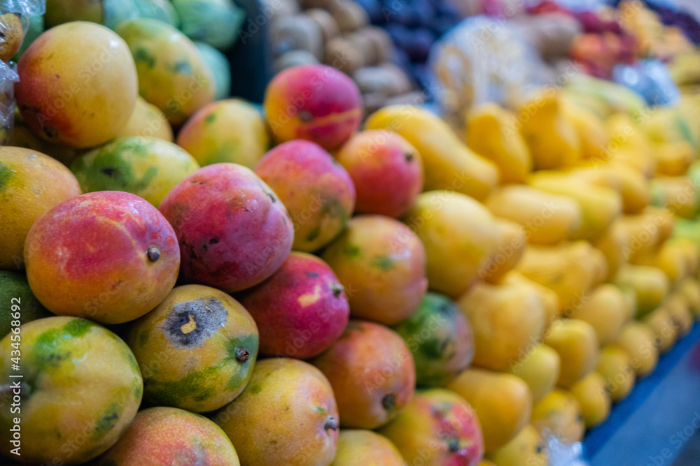 Close-up of a colorful fruit stand with fresh mangoes Close-up of a colorful fruit stand with fresh mangoes