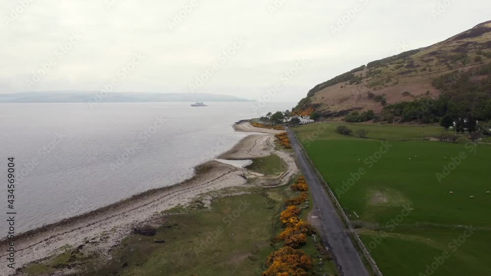 Aerial view of the Scottish town of Catacol on the Isle of Arran on an overcast day, Scotland. Right to left view flying towards the town. Aerial view of the Scottish town of Catacol on the Isle of Arran on an overcast day, Scotland. Right to left view flying towards the town.