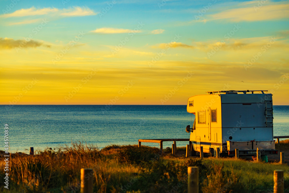 Camper vehicle on beach at sunrise Camper vehicle on beach at sunrise