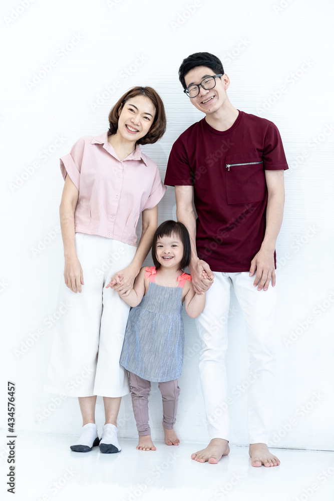 Father and mother, children, girls, disabilities and cerebral development, down syndrome, photographed portraits. The family stood happily smiling together on a white background. Father and mother, children, girls, disabilities and cerebral development, down syndrome, photographed portraits. The family stood happily smiling together on a white background.