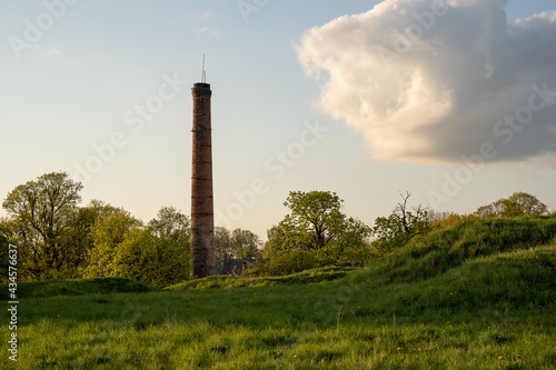 on the hill in the middle of the green hall is a large brick chimney with a fluffy macaque in the sky