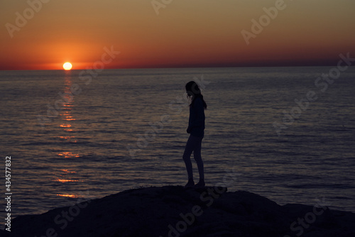 silhouette of a woman by the sea in the mountains in nature