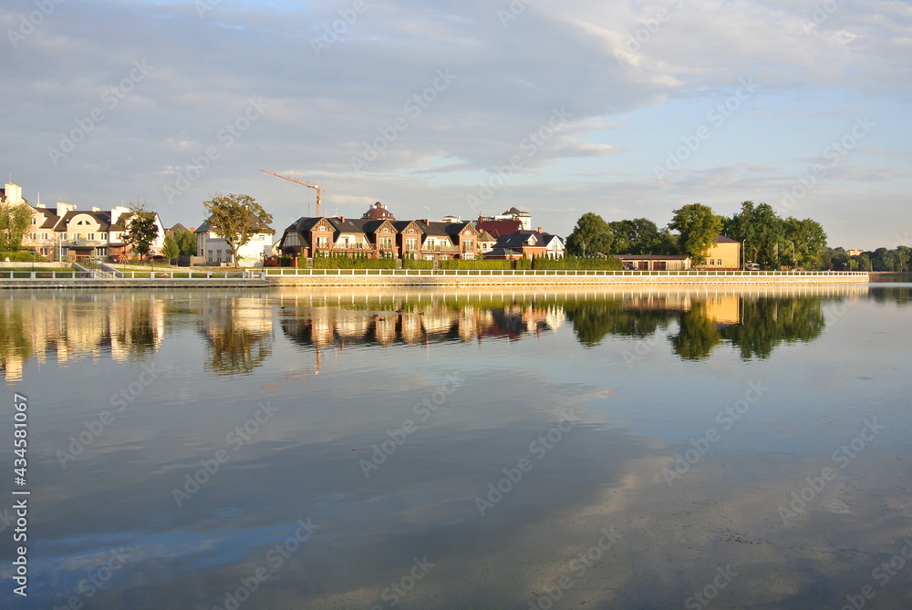 Line of the houses reflect in water. Suburb district behind the river in Kaliningrad, Russia  