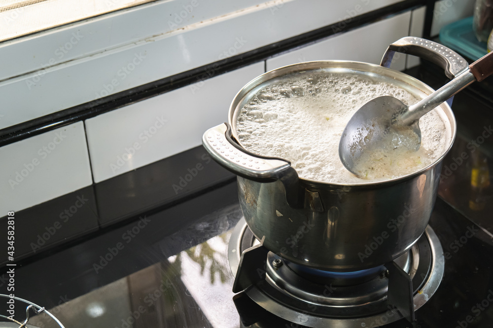 Boiling soup in stainless steel pot over gas stove. Boiling soup in stainless steel pot over gas stove.