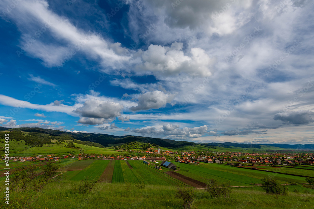 Obraz premium View from the top of a hill, hungarian village in Transylvania, Romania at springtime.