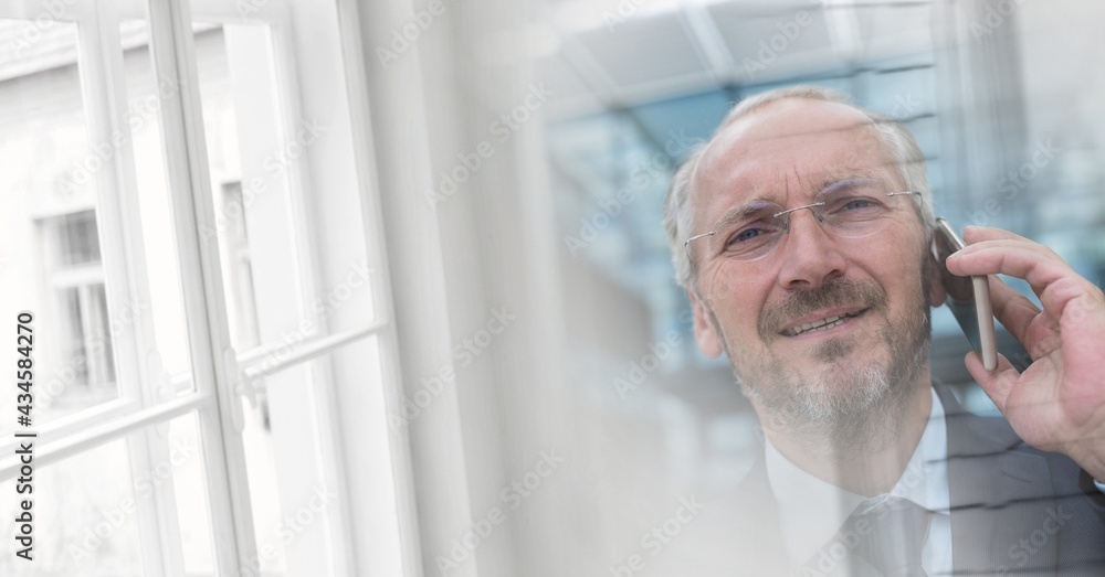 Composition of smiling businessman talking on smartphone in office with double exposure
