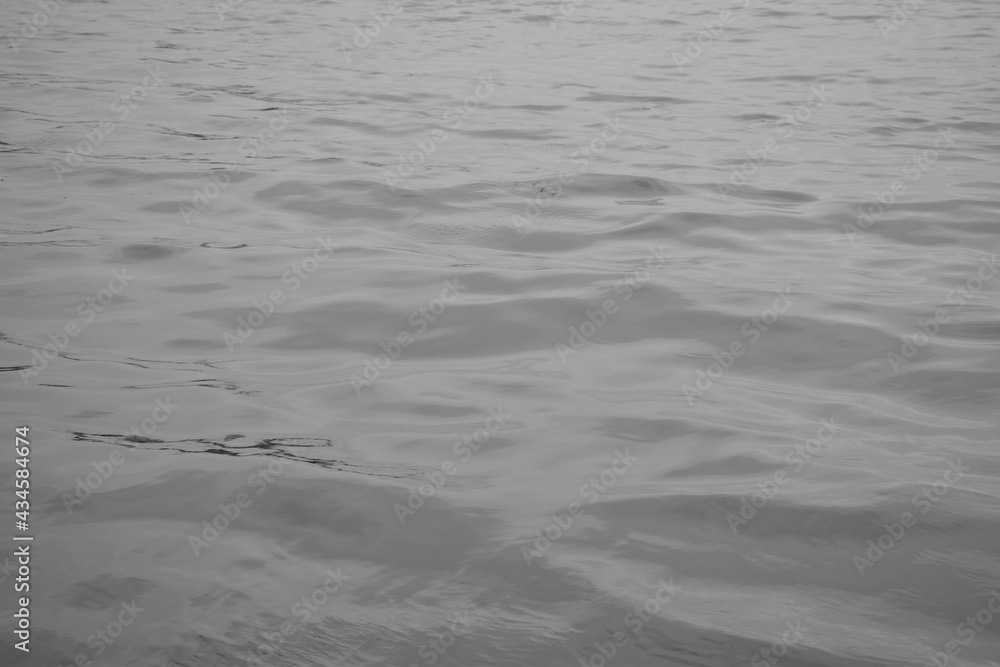 Monochrome Waves rippling through water fading off showing concept of peaceful loneliness and solitude Monochrome Waves rippling through water fading off showing concept of peaceful loneliness and solitude