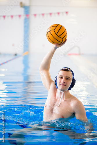 Water polo training. Young sportsman plays water polo in the pool. photo